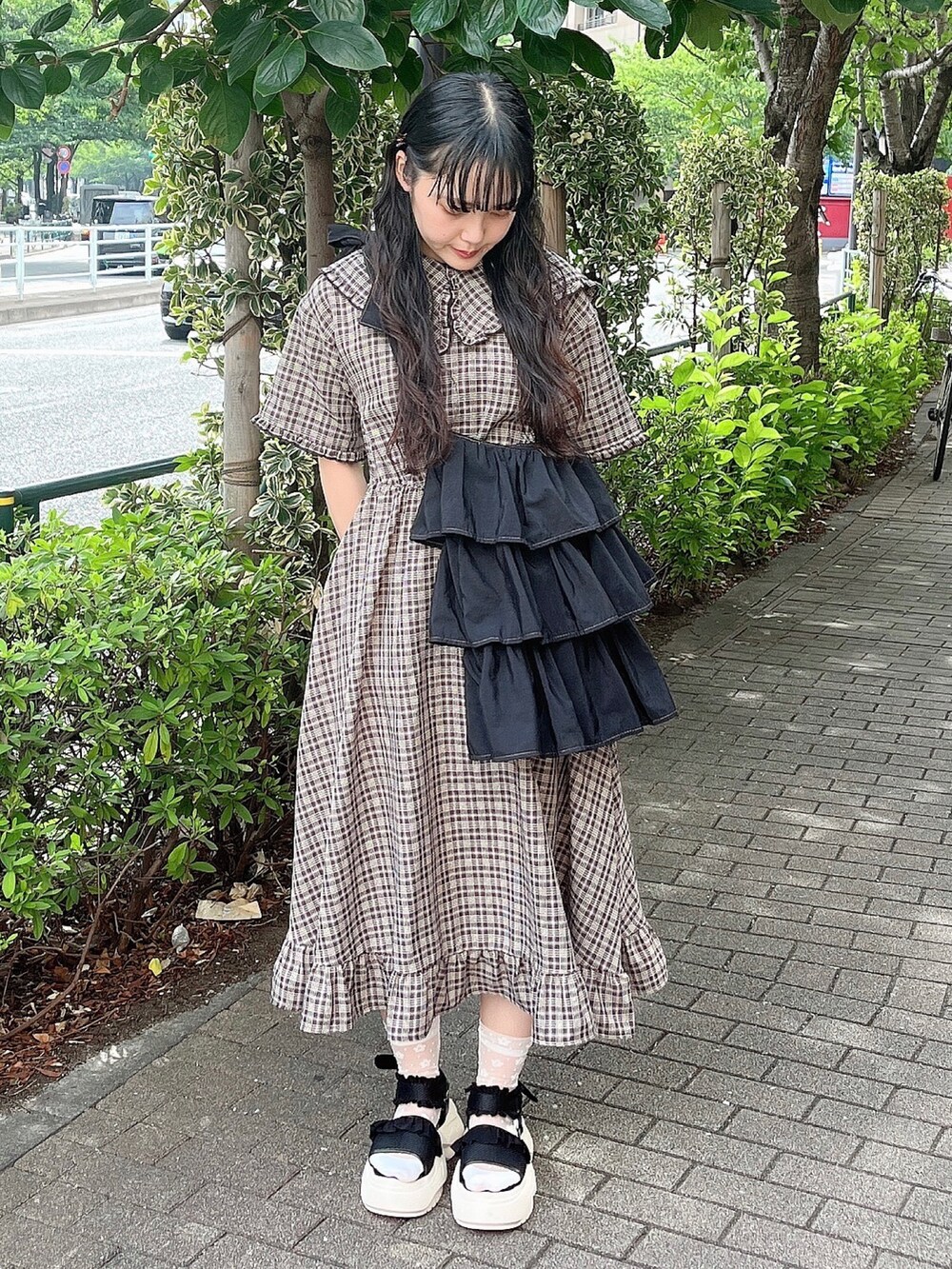 ブラウン系のワンピース、ブラック系のショルダーバッグ、ブラック系のサンダルを着用したレディースの夏コーディネートの2枚目の写真