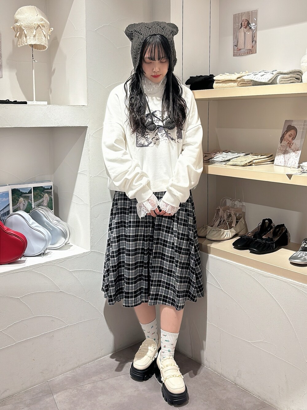 ホワイト系のニット/セーター、ホワイト系のスウェット、ブラック系のスカートを着用したレディースの秋コーディネートの2枚目の写真