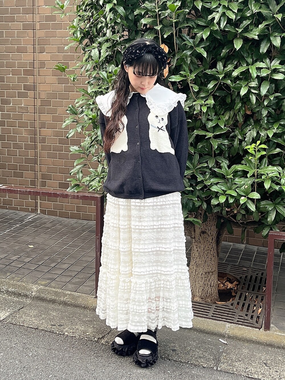 ホワイト系のシャツ/ブラウス、ブラック系のカーディガン/ボレロ、ホワイト系のスカートを着用したレディースの夏コーディネートの2枚目の写真