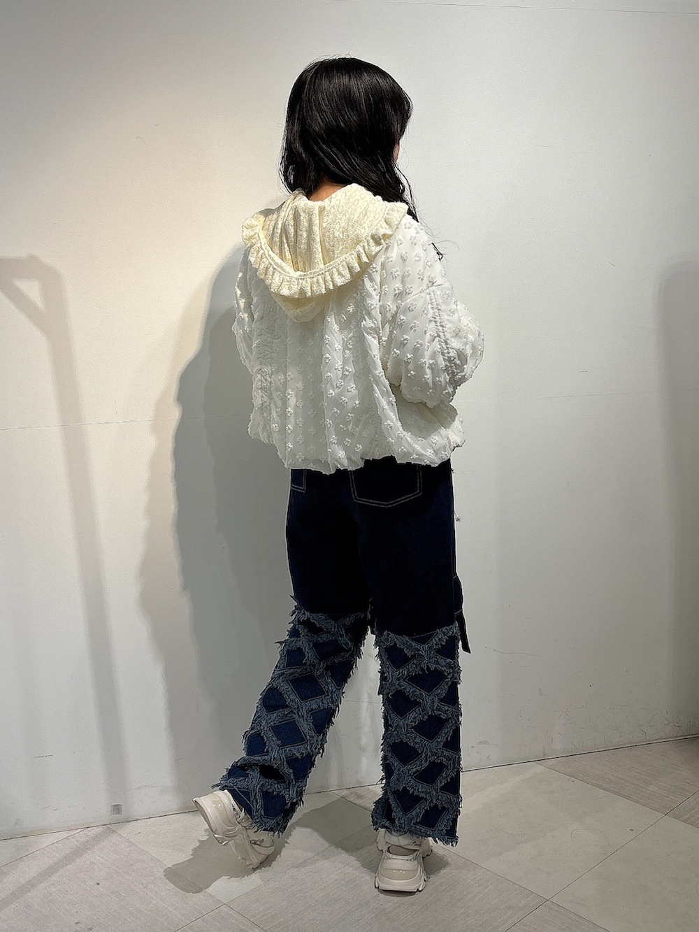 ホワイト系のジャージ、ブルー系のデニムパンツ、ホワイト系のスニーカーを着用したレディースの秋コーディネートの4枚目の写真