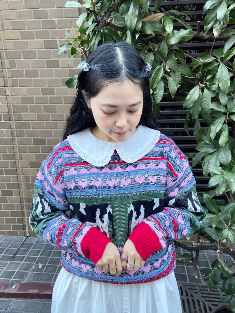 ベージュ系のパンプス、レッド系のニット/セーター、ホワイト系のワンピースを着用したレディースの冬コーディネートの4枚目の写真