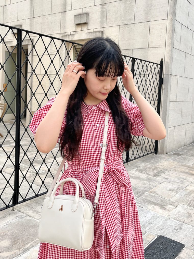 ホワイト系のショルダーバッグ、ホワイト系のサンダル、レッド系のワンピースを着用したレディースの夏コーディネートの3枚目の写真