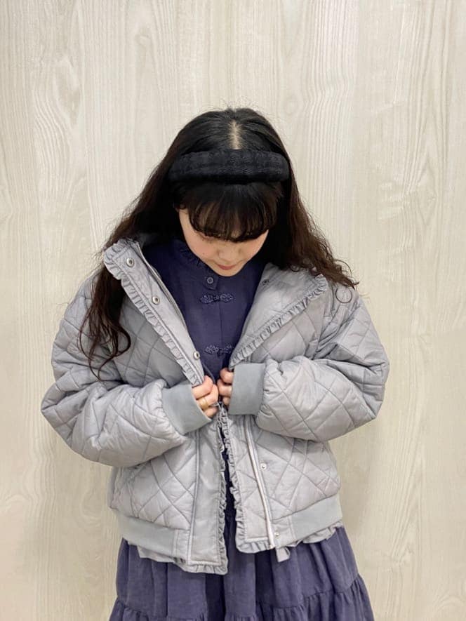 ブルー系のナイロンジャケット、パープル系のワンピース、ブラック系のブーツを着用したレディースの冬コーディネートの5枚目の写真