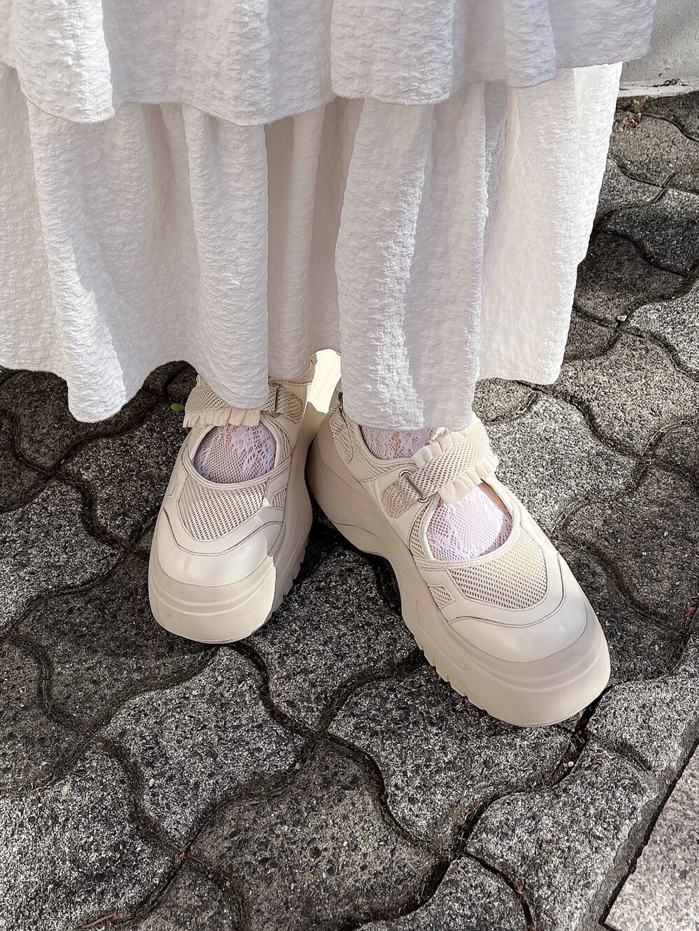 ホワイト系のスウェット、ブルー系のブルゾン、ホワイト系のスカートを着用したレディースの冬コーディネートの8枚目の写真