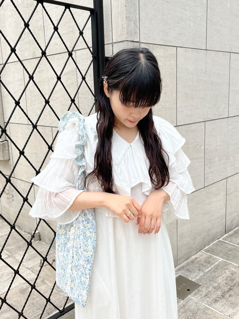 ホワイト系のワンピース、ホワイト系のサンダル、ブルー系のトートバッグを着用したレディースの春コーディネートの2枚目の写真