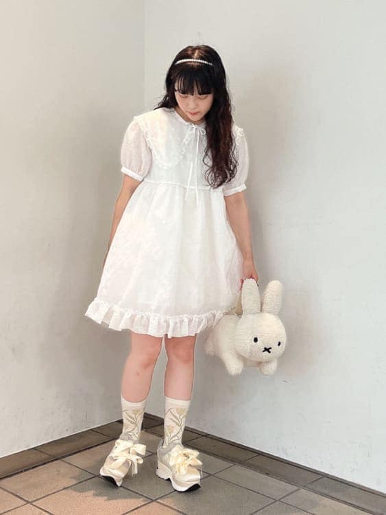 ホワイト系のスニーカー、ホワイト系のワンピース、ホワイト系のハンドバッグを着用したレディースの夏コーディネートの2枚目の写真