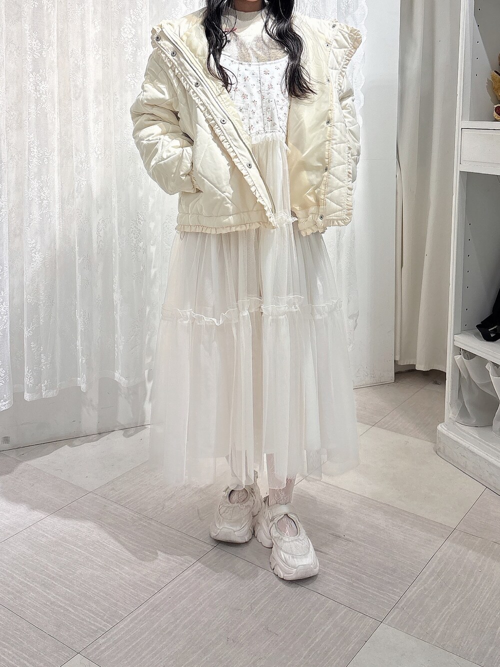 ホワイト系のニット/セーター、ホワイト系のダウンジャケット/コート、ホワイト系のワンピースを着用したレディースの冬コーディネートの2枚目の写真