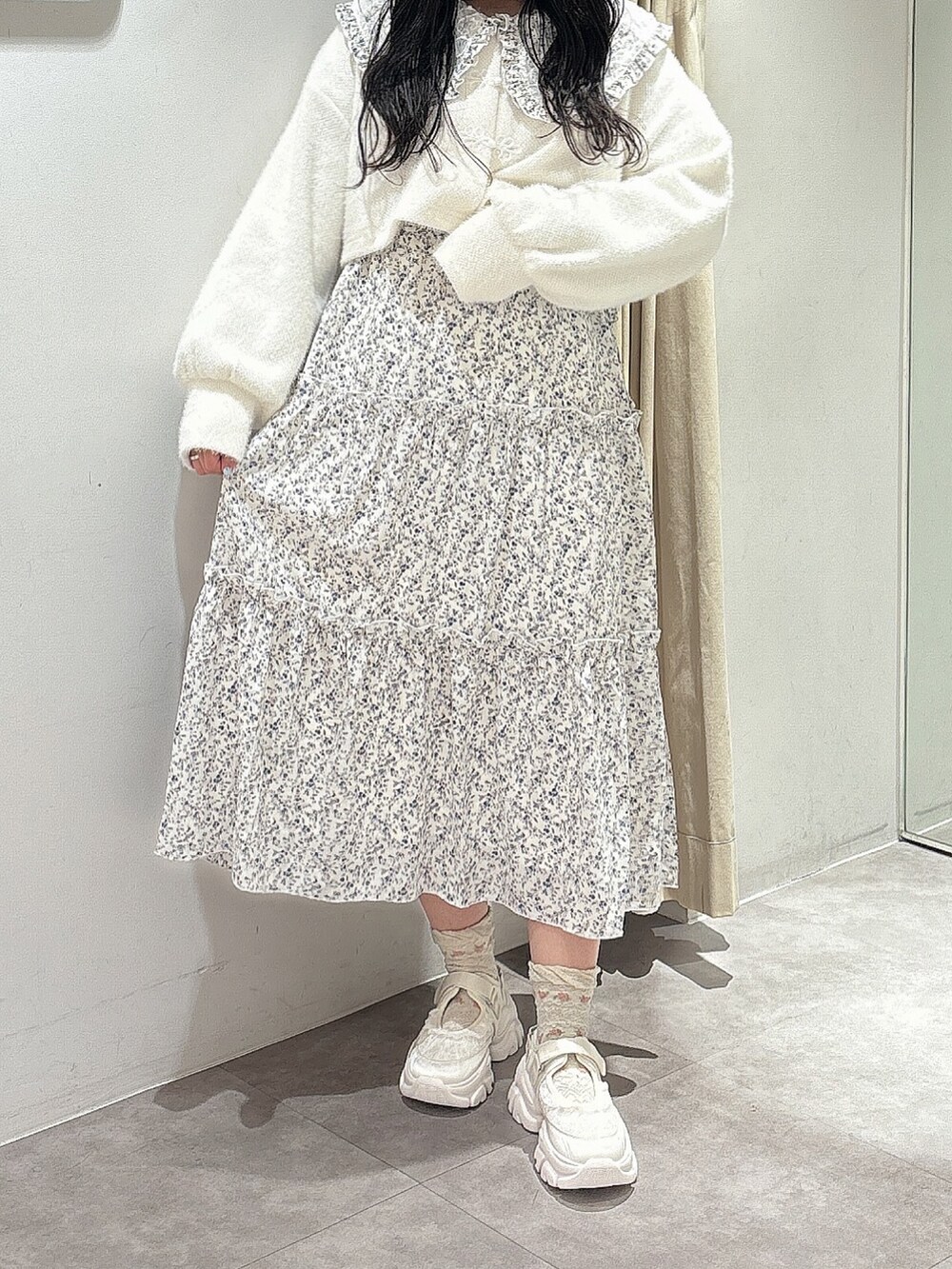 ホワイト系のカーディガン/ボレロ、ホワイト系のワンピース、ホワイト系のスニーカーを着用したレディースの秋コーディネートの2枚目の写真