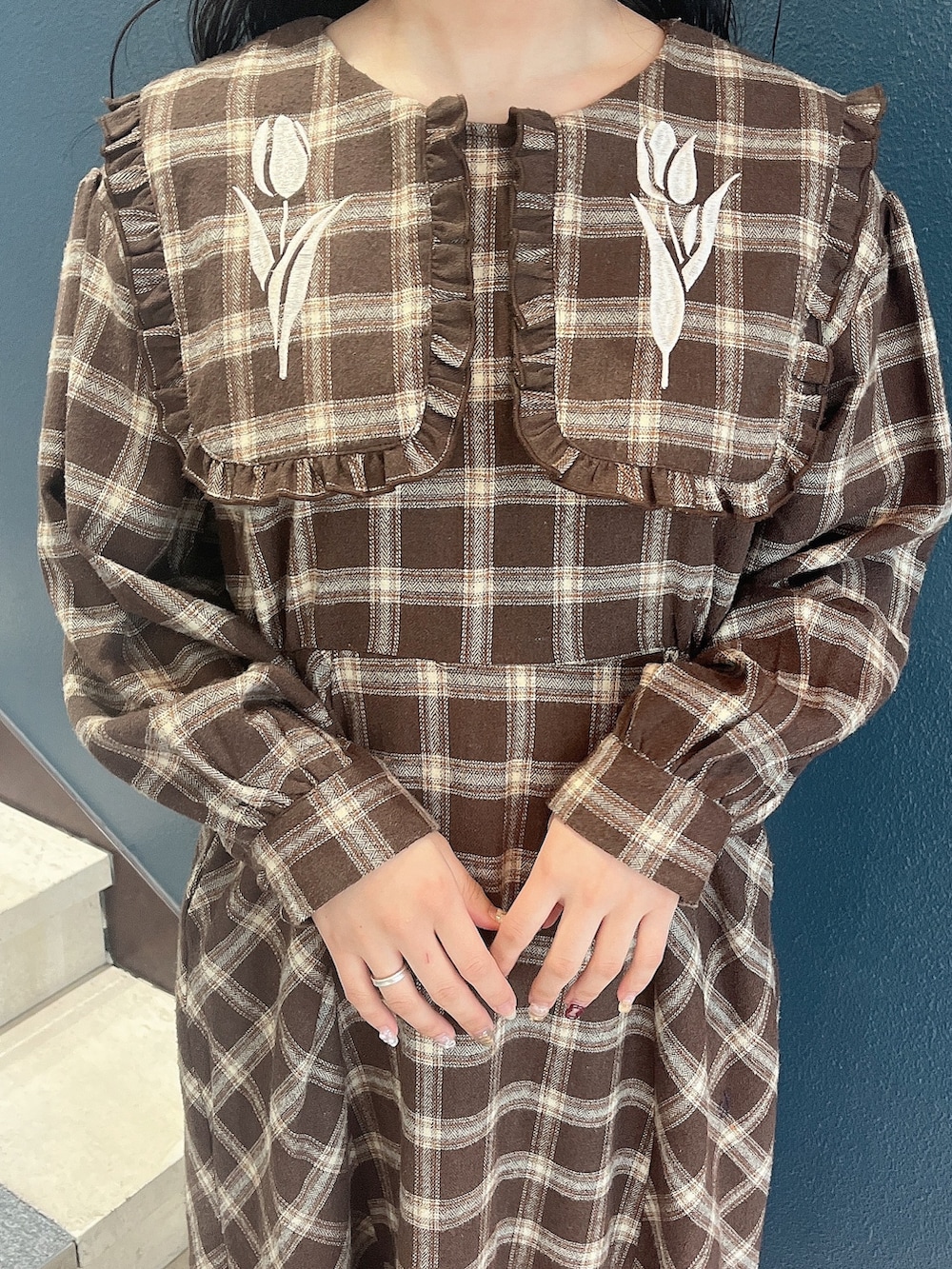 ブラウン系のワンピース、ホワイト系のスニーカーを着用したレディースの冬コーディネートの4枚目の写真