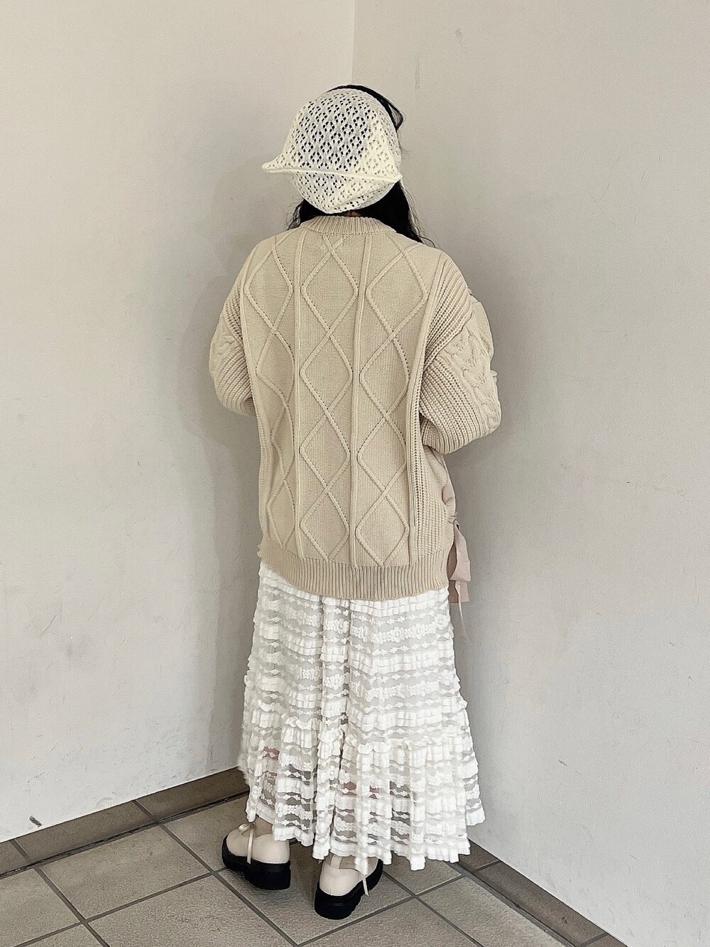 ホワイト系のニット/セーター、ホワイト系のスカート、ホワイト系のブーツを着用したレディースの秋コーディネートの3枚目の写真