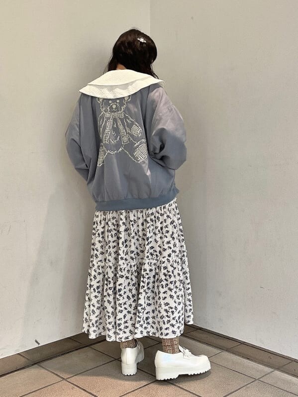 ホワイト系のパンプス、ホワイト系のスカート、ブルー系のブルゾンを着用したレディースの秋コーディネートの3枚目の写真