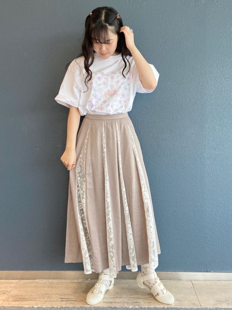 ベージュ系のスカート、ホワイト系のパンプス、ホワイト系のトートバッグを着用したレディースの夏コーディネートの2枚目の写真
