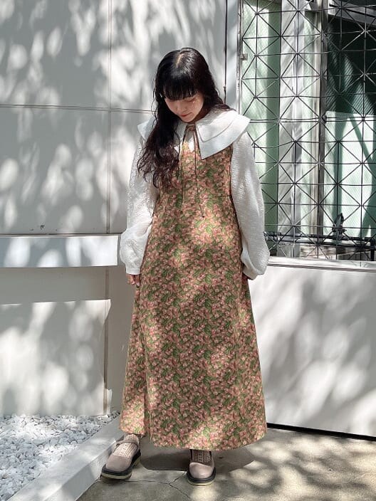 グリーン系のノーカラーコート、ベージュ系のパンプス、ホワイト系のシャツ/ブラウスを着用したレディースの秋コーディネートの2枚目の写真