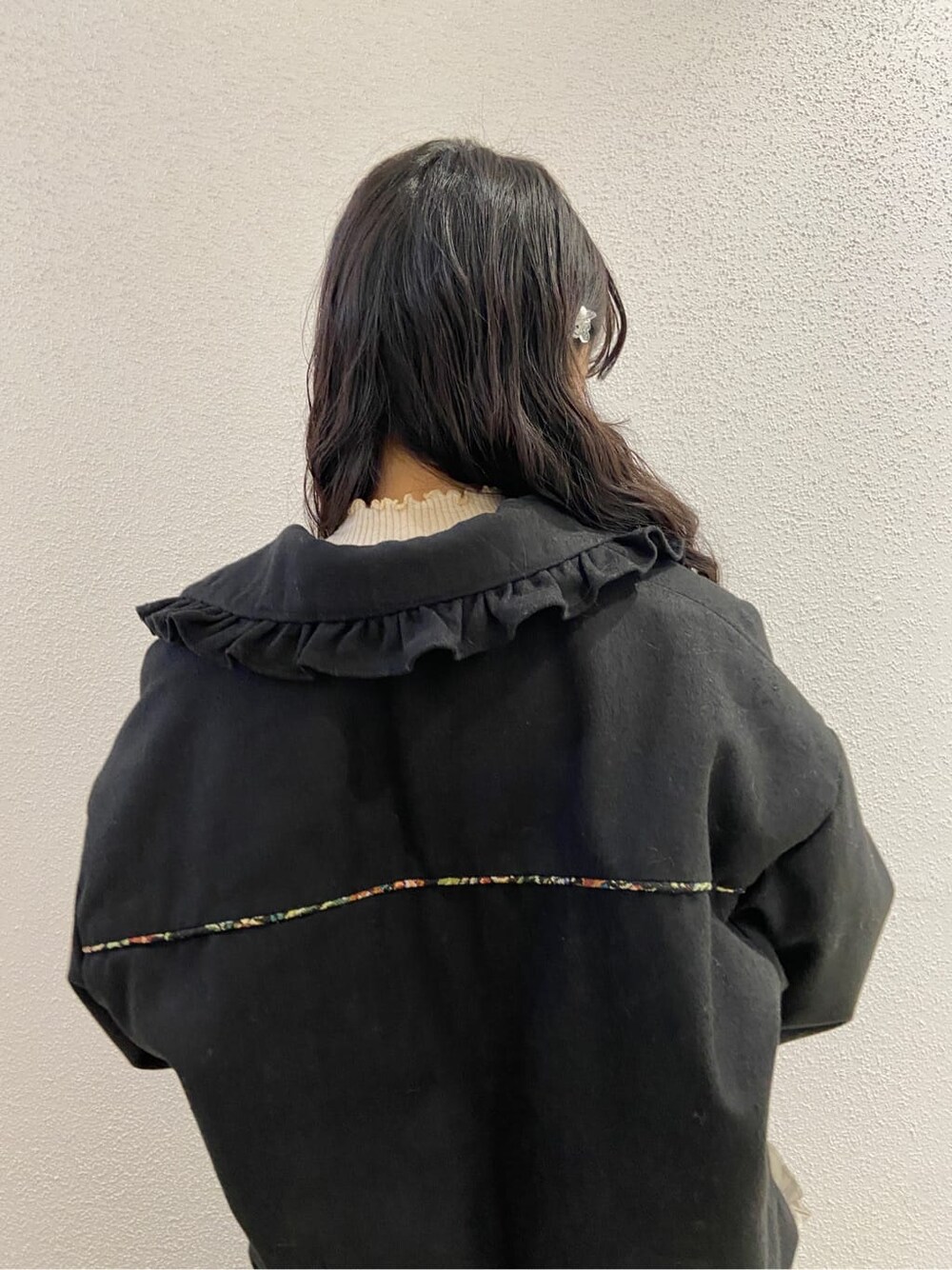 ブラック系のハンドバッグ、ブラック系のブーツ、ベージュ系のスカートを着用したレディースの冬コーディネートの5枚目の写真