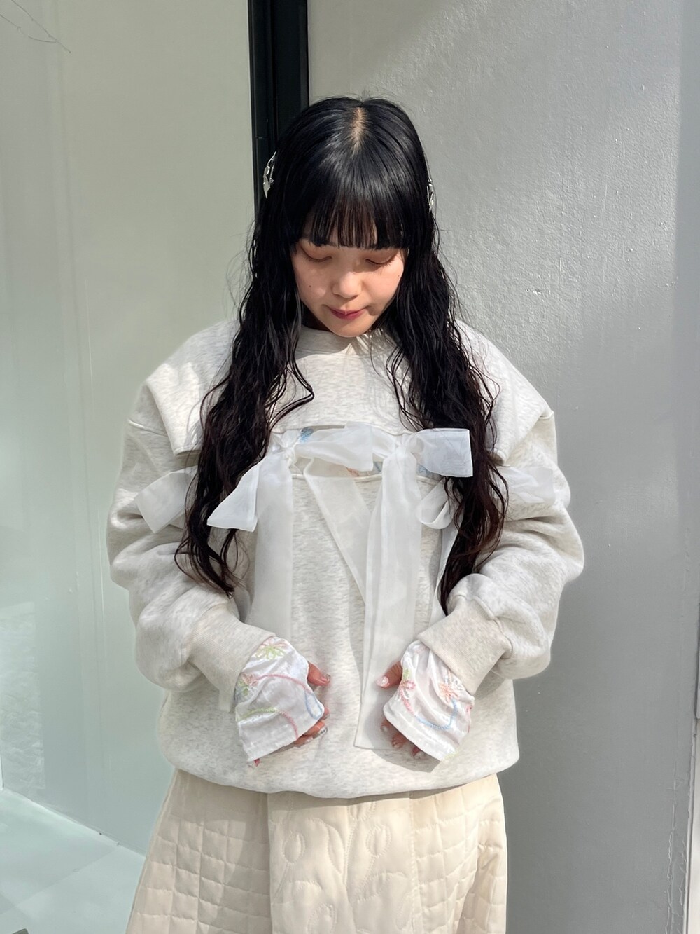ホワイト系のスウェット、ホワイト系のTシャツ/カットソー、ホワイト系のスカートを着用したレディースの冬コーディネートの6枚目の写真