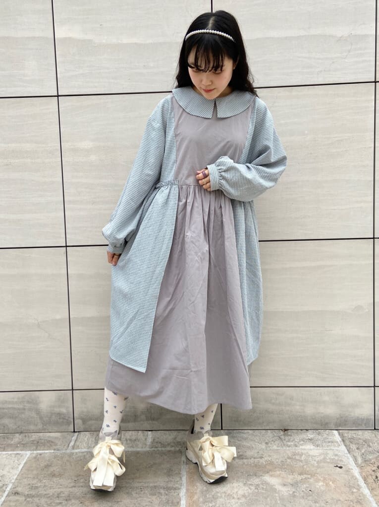 ホワイト系のカーディガン/ボレロ、ホワイト系のスニーカー、グレー系のワンピースを着用したレディースの冬コーディネートの3枚目の写真