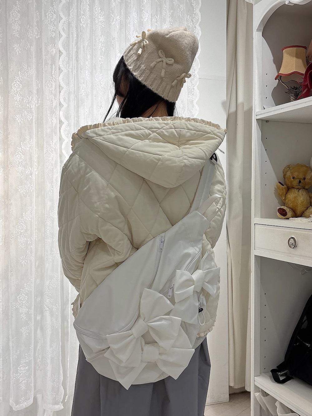 グレー系のスウェット、ホワイト系のダウンジャケット/コート、ホワイト系のショルダーバッグを着用したレディースの冬コーディネートの6枚目の写真