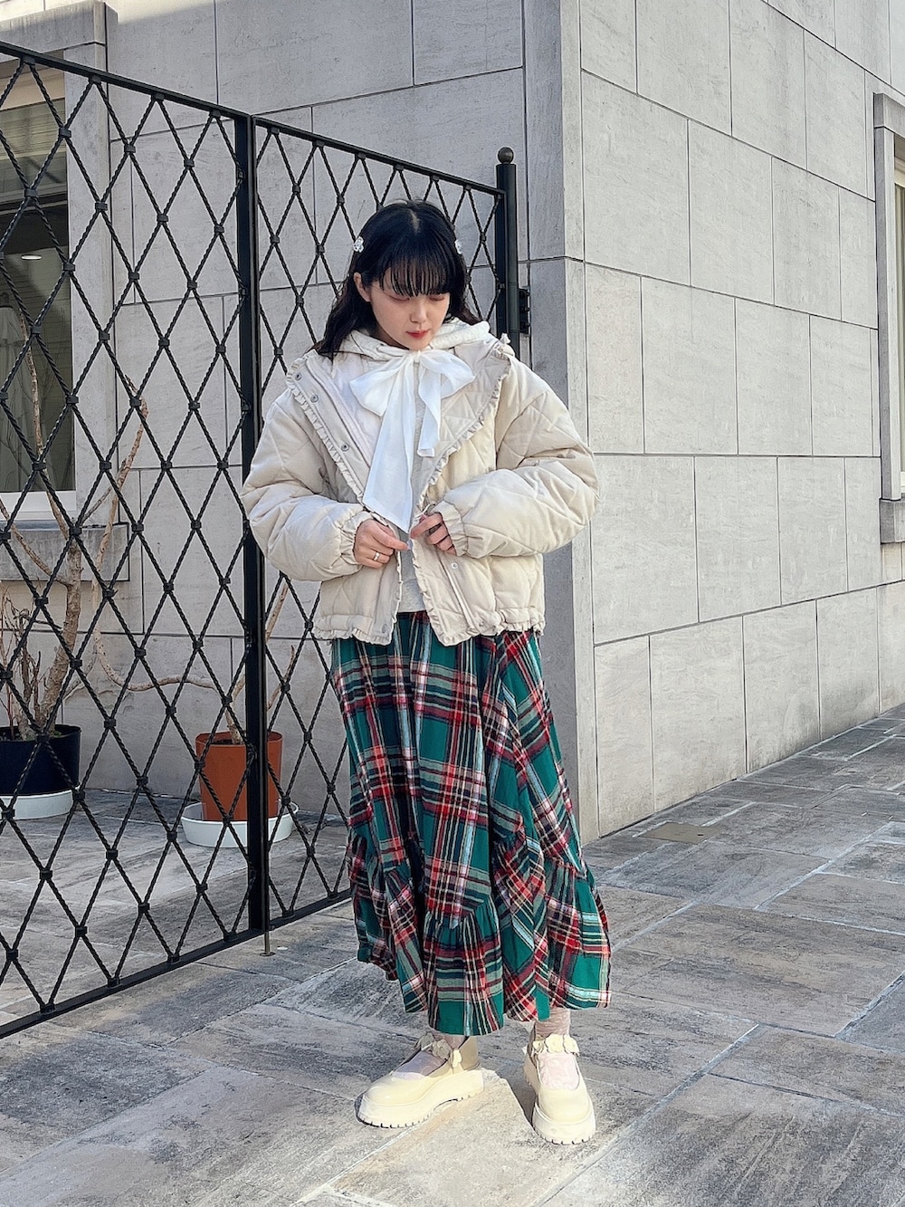 ホワイト系のパーカー、ホワイト系のその他アウター、グリーン系のスカートを着用したレディースの冬コーディネートの2枚目の写真