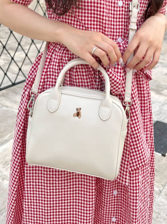 ホワイト系のショルダーバッグ、ホワイト系のサンダル、レッド系のワンピースを着用したレディースの夏コーディネートの4枚目の写真