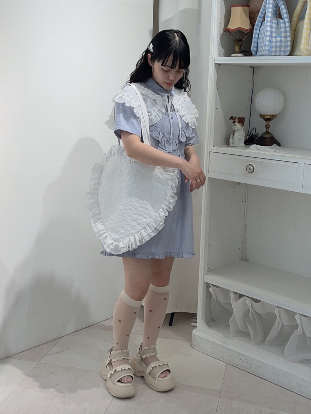 ブルー系のワンピース、ホワイト系のトートバッグ、ホワイト系のサンダルを着用したレディースの春コーディネートの2枚目の写真