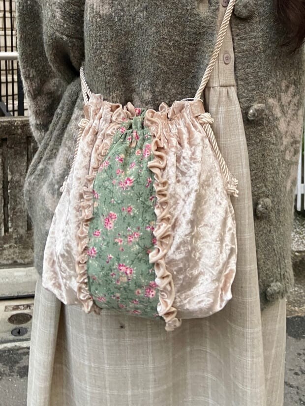 ホワイト系のブーツ、ホワイト系のハンドバッグ、ベージュ系のワンピースを着用したレディースの冬コーディネートの6枚目の写真