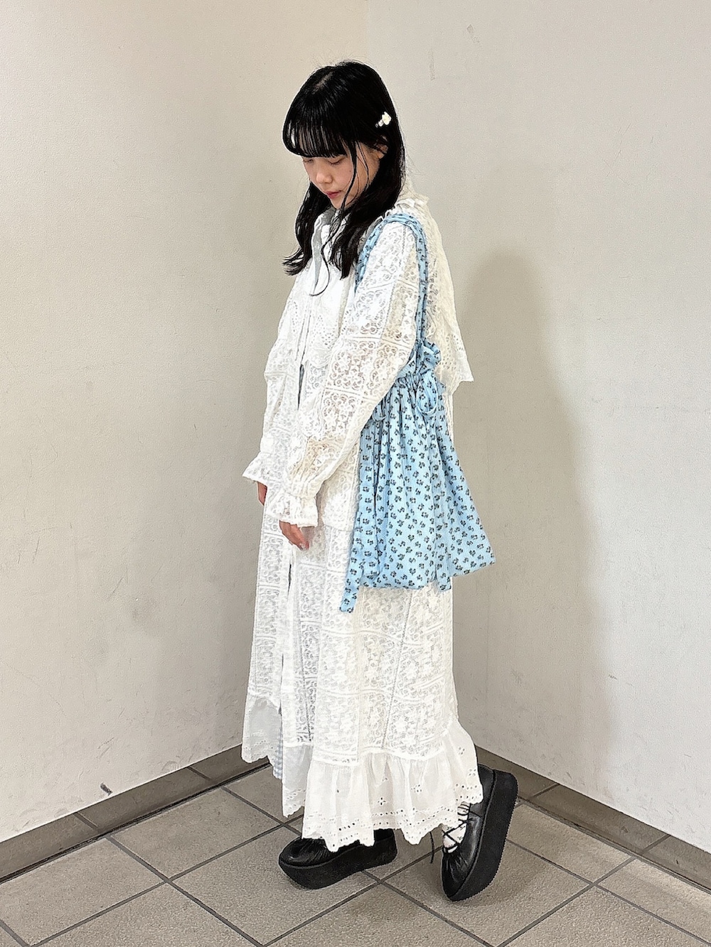 ブルー系のワンピース、ホワイト系のトレンチコート、ブラック系のバレエシューズを着用したレディースの春コーディネートの3枚目の写真