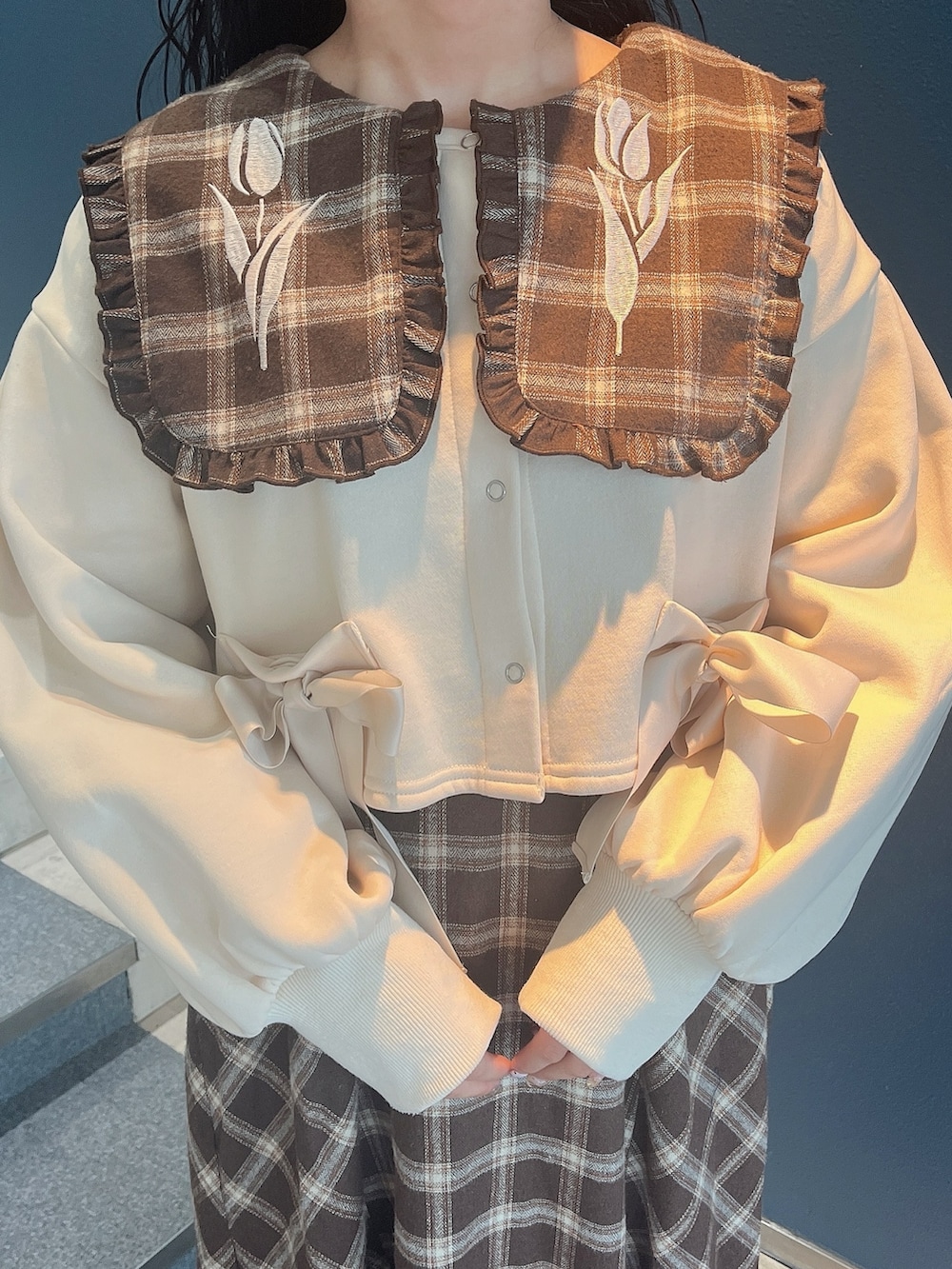 ブラウン系のワンピース、ホワイト系のカーディガン/ボレロ、ホワイト系のスニーカーを着用したレディースの冬コーディネートの5枚目の写真