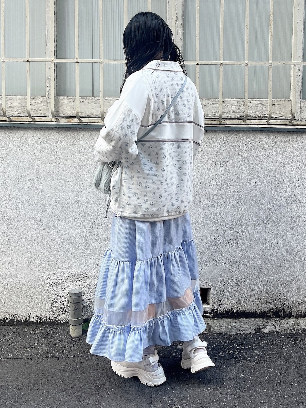 ホワイト系のスウェット、ブルー系のジャージ、ブルー系のショルダーバッグを着用したレディースの春コーディネートの5枚目の写真