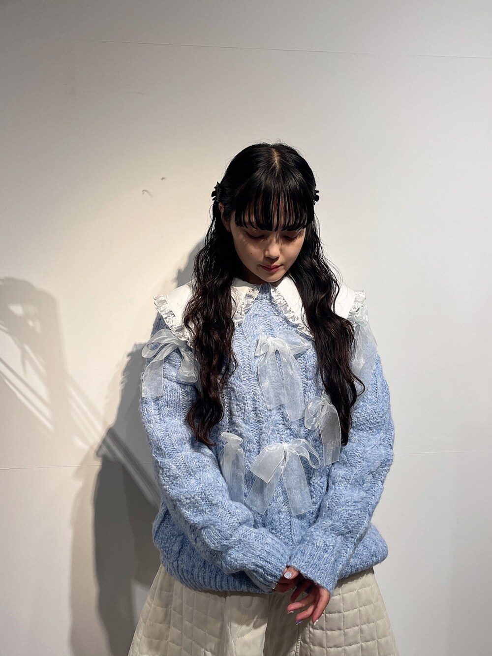 ホワイト系のシャツ/ブラウス、ブルー系のニット/セーター、ホワイト系のスカートを着用したレディースの秋コーディネートの6枚目の写真