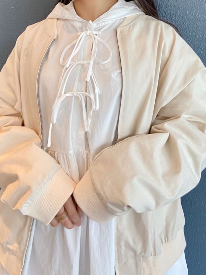 ホワイト系のブルゾン、ホワイト系のワンピース、ベージュ系のパンプスを着用したレディースの夏コーディネートの6枚目の写真