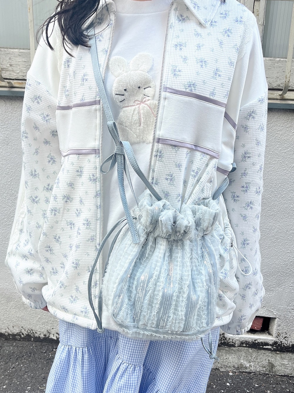 ホワイト系のスウェット、ブルー系のジャージ、ブルー系のショルダーバッグを着用したレディースの春コーディネートの8枚目の写真