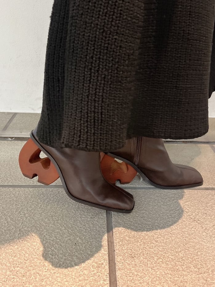 ブラウン系のブーツ、ブラウン系のブーツ、ブラック系のスカートを着用したレディースの秋コーディネートの6枚目の写真