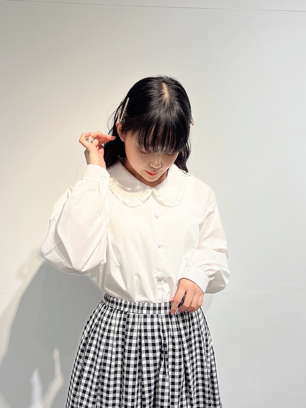 ホワイト系のシャツ/ブラウス、ブラック系のスカート、ホワイト系のパンプスを着用したレディースの春コーディネートの4枚目の写真