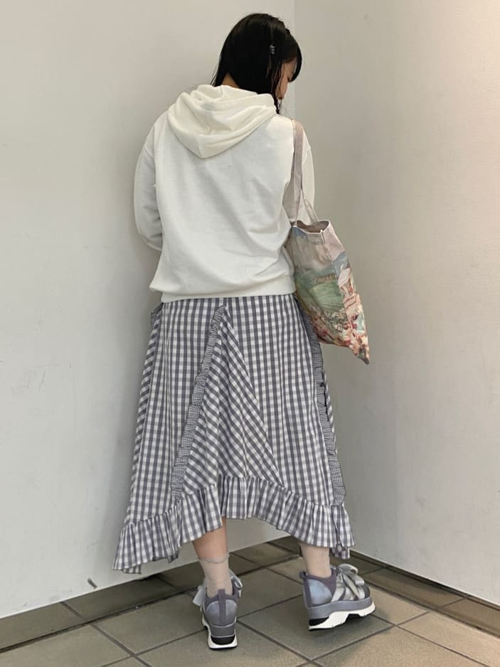 グレー系のスカート、ブルー系のスニーカー、ホワイト系のTシャツ/カットソーを着用したレディースの秋コーディネートの2枚目の写真