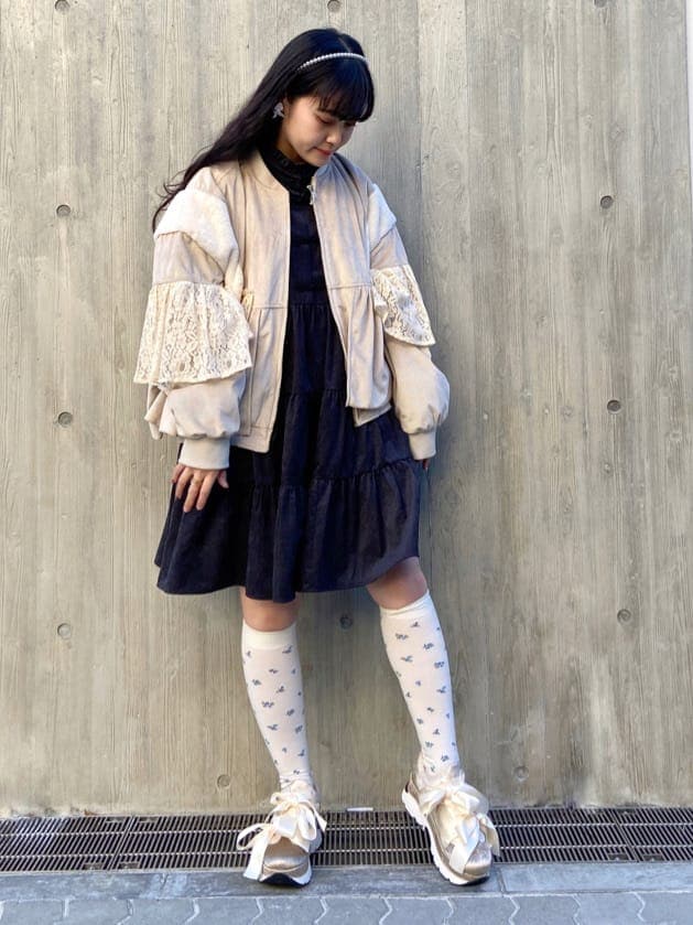 ホワイト系のブルゾン、ブラック系のワンピース、ホワイト系のスニーカーを着用したレディースの冬コーディネートの2枚目の写真