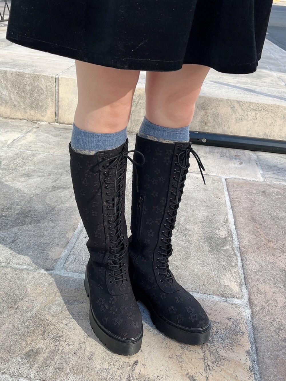 ブラック系のワンピース、ホワイト系のボストンバッグ、ブラック系のブーツを着用したレディースの冬コーディネートの8枚目の写真