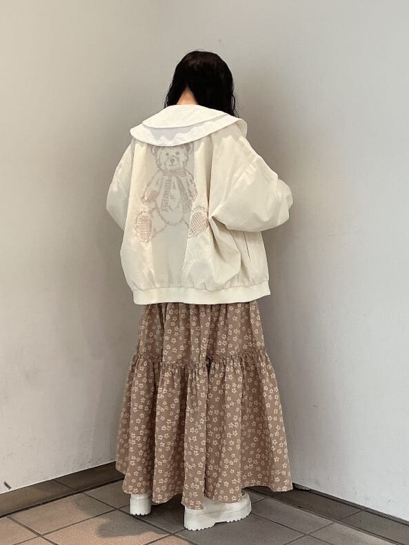 ホワイト系のブルゾン、ホワイト系のシャツ/ブラウス、ベージュ系のスカートを着用したレディースの秋コーディネートの2枚目の写真