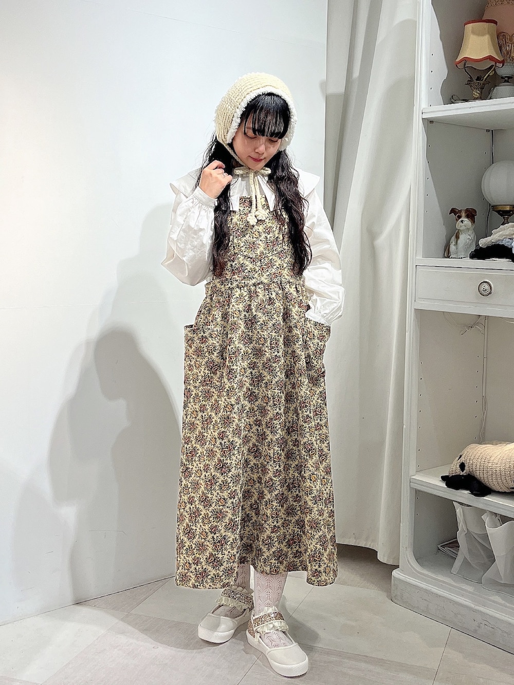 ホワイト系のシャツ/ブラウス、ベージュ系のジャンパースカート、ホワイト系のスニーカーを着用したレディースの秋コーディネートの2枚目の写真