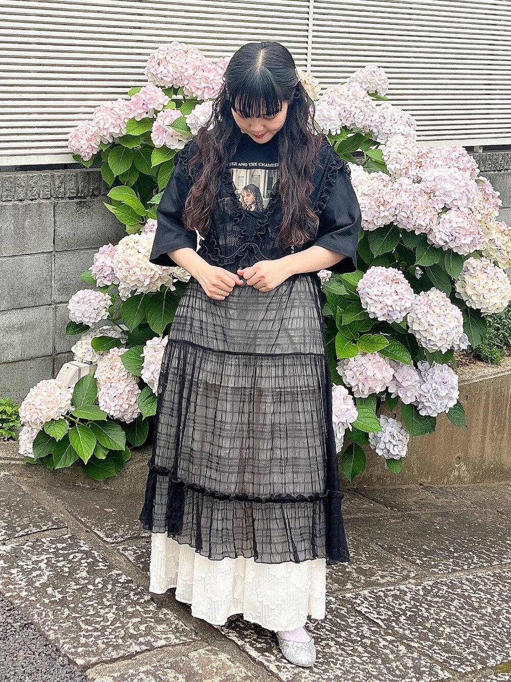 ブラック系のTシャツ/カットソー、シルバー系のパンプス、ホワイト系のスカートを着用したレディースの夏コーディネートの2枚目の写真