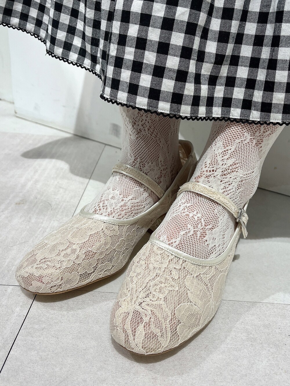 ホワイト系のシャツ/ブラウス、ブラック系のスカート、ホワイト系のパンプスを着用したレディースの春コーディネートの7枚目の写真