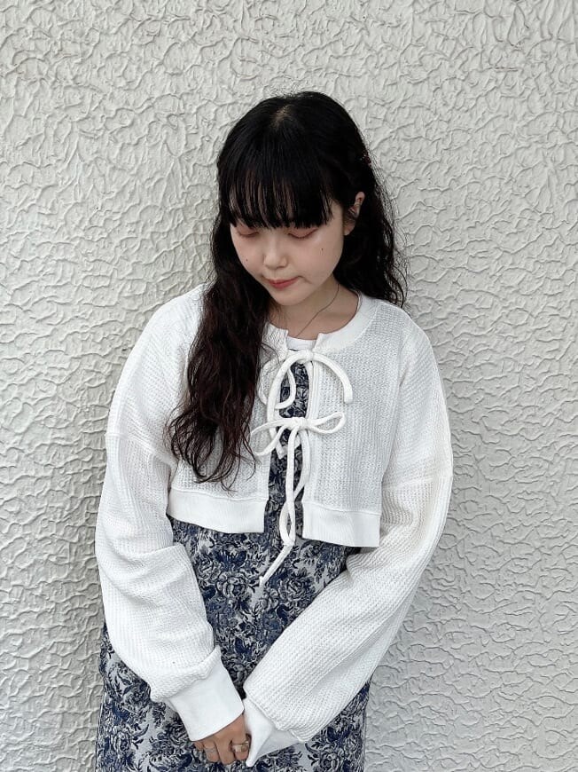 ベージュ系のサンダル、ブルー系のジャンパースカート、ホワイト系のカーディガン/ボレロを着用したレディースの夏コーディネートの3枚目の写真