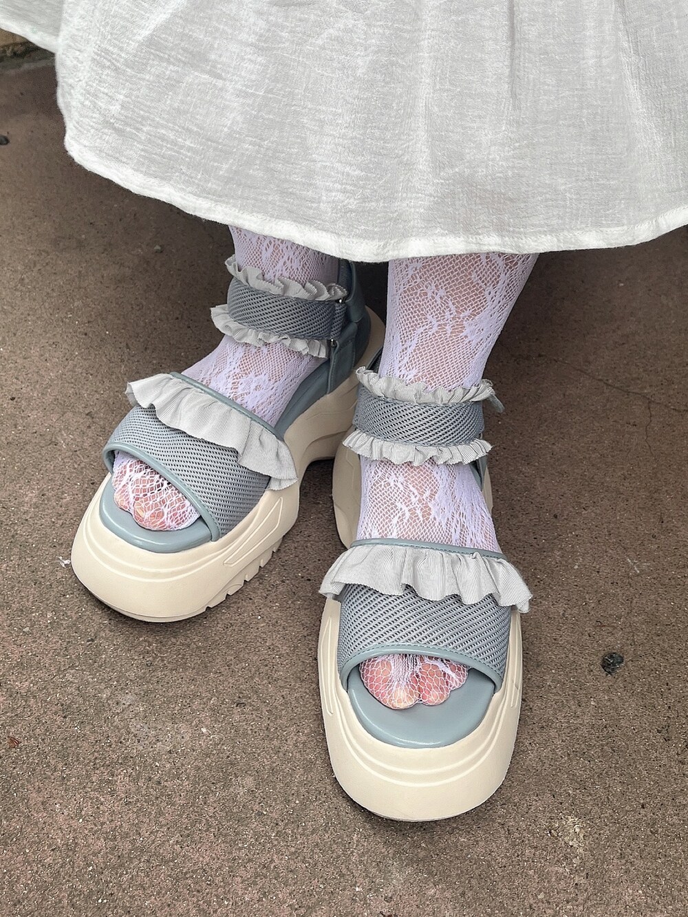 グレー系のTシャツ/カットソー、ホワイト系のスカート、ブルー系のサンダルを着用したレディースの夏コーディネートの7枚目の写真