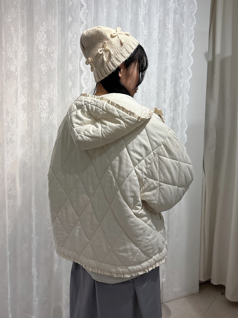 グレー系のスウェット、ホワイト系のダウンジャケット/コート、ホワイト系のショルダーバッグを着用したレディースの冬コーディネートの5枚目の写真