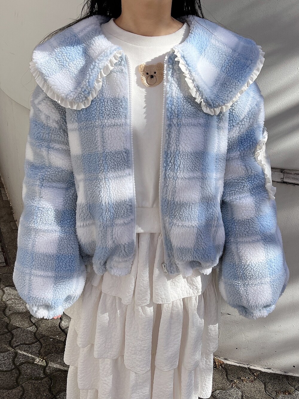 ホワイト系のスウェット、ブルー系のブルゾン、ホワイト系のスカートを着用したレディースの冬コーディネートの7枚目の写真