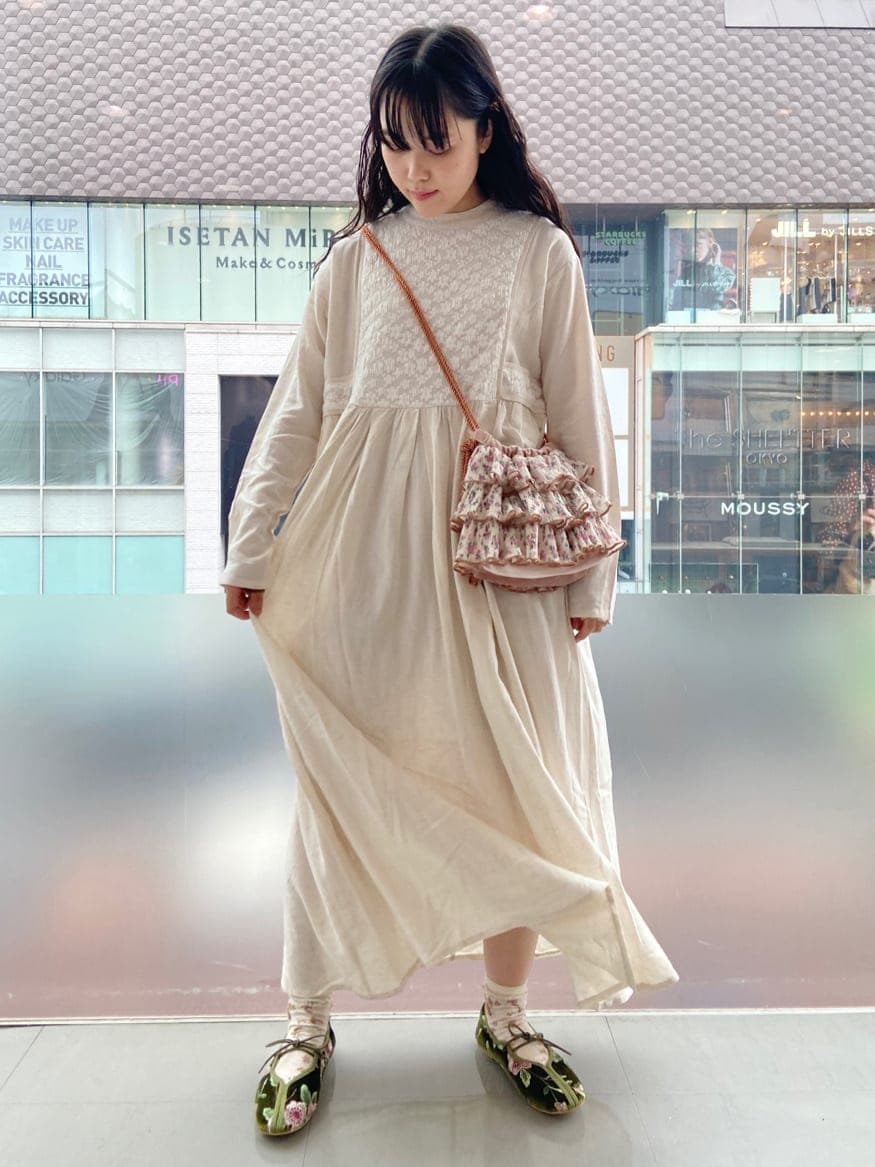 ホワイト系のテーラードジャケット、オレンジ系のハンドバッグ、ホワイト系のワンピースを着用したレディースの夏コーディネートの2枚目の写真