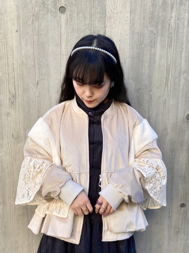 ホワイト系のブルゾン、ブラック系のワンピース、ホワイト系のスニーカーを着用したレディースの冬コーディネートの4枚目の写真