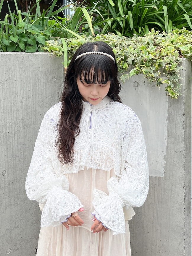 ホワイト系のワンピース、ホワイト系のパンプス、パープル系のチュニックを着用したレディースの秋コーディネートの2枚目の写真
