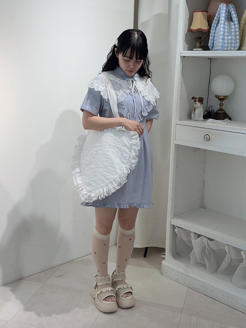 ブルー系のワンピース、ホワイト系のトートバッグ、ホワイト系のサンダルを着用したレディースの春コーディネートの3枚目の写真