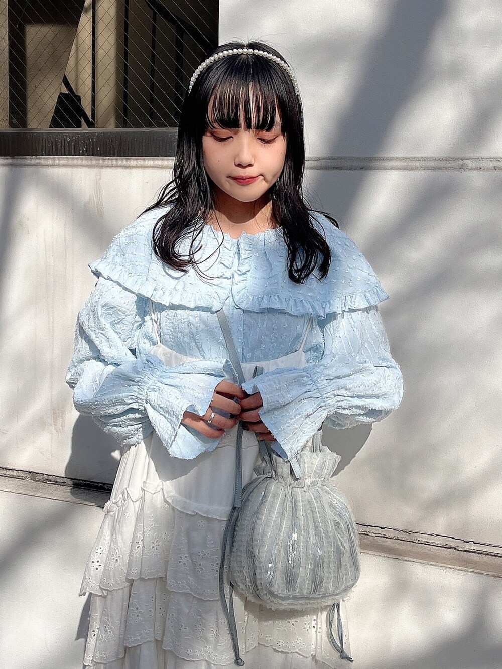 ブルー系のシャツ/ブラウス、ブルー系のショルダーバッグ、ホワイト系のワンピースを着用したレディースの冬コーディネートの6枚目の写真