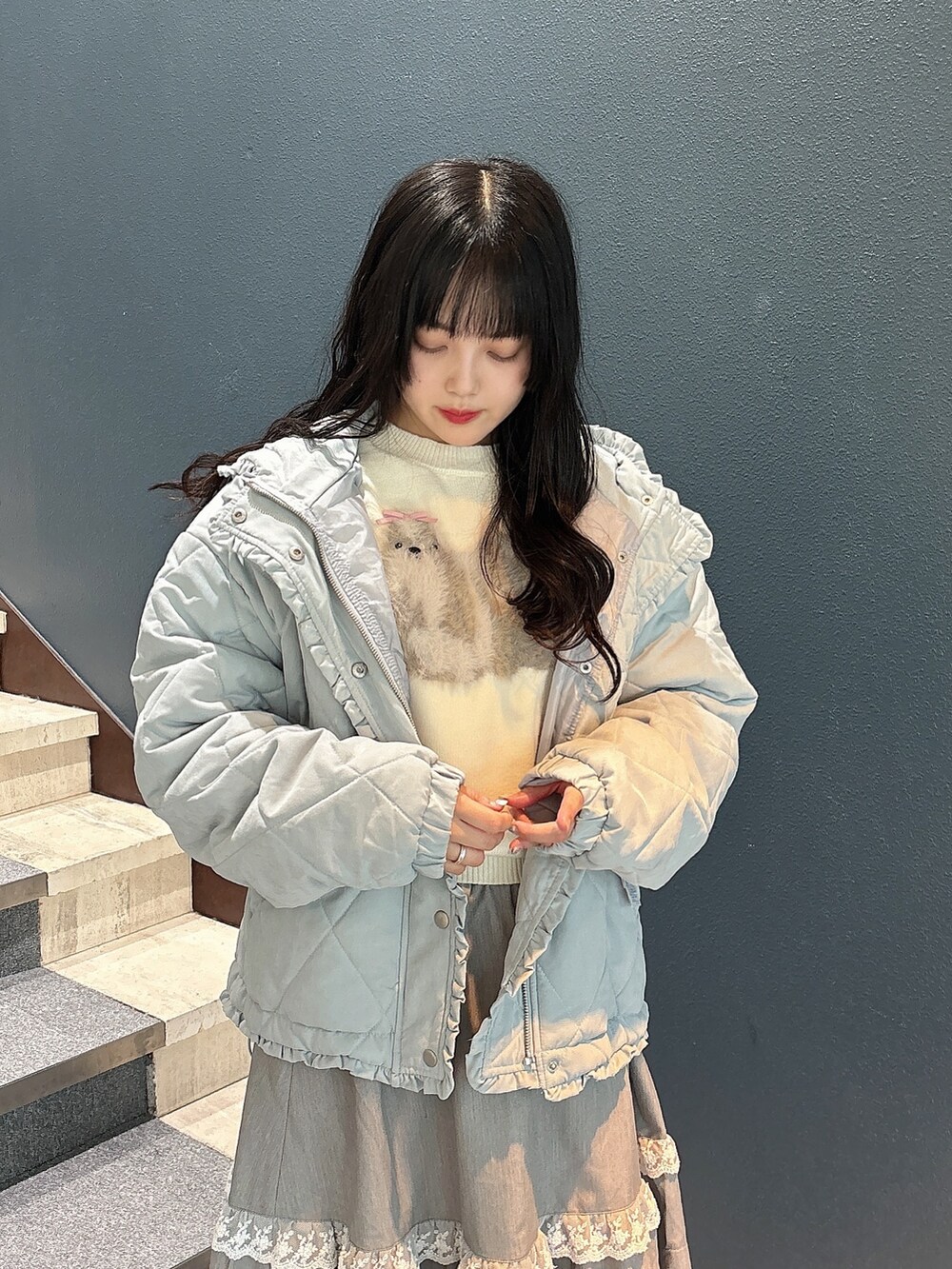 ブルー系のダウンジャケット/コート、ホワイト系のニット/セーター、グレー系のスカートを着用したレディースの秋コーディネートの6枚目の写真